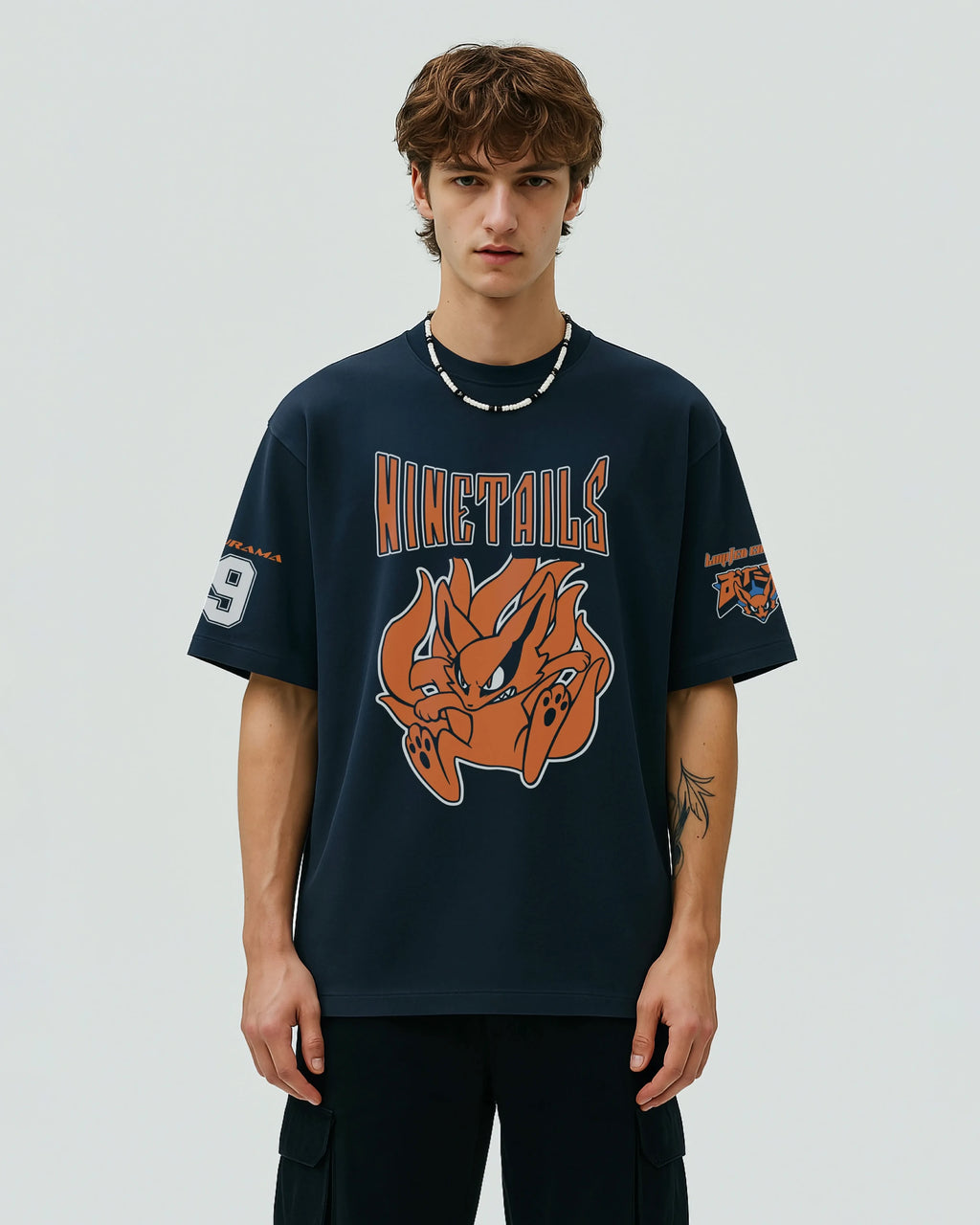 Person wearing a navy blue oversized t-shirt jersey with a ninetails graphic from naruto and text on a plain background